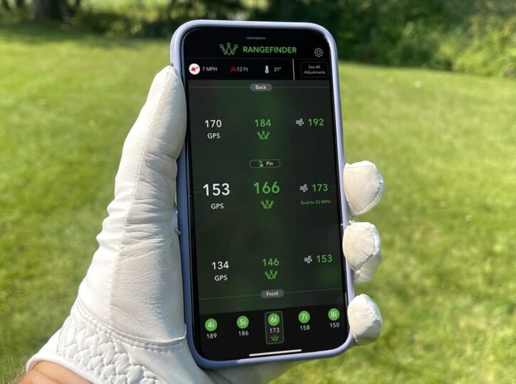 arccos caddie review - golfer holding phone
